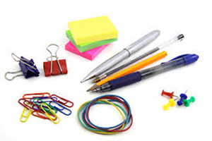 A table topped with pens, pencils and paper clips.