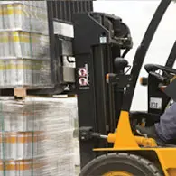 A forklift is moving pallets of beer.