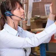 A woman wearing headphones and holding her hand up to the ceiling.